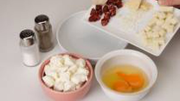 Cortar la mozzarella, mezclar con el requesón, el parmesano, el chorizo en taquitos y los huevos batidos.  Salpimentar.