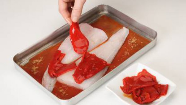 Cubre la merluza con los pimientos del piquillo e introdúcela en el horno durante 8 minutos a una temperatura alta.