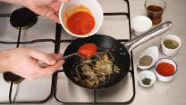 Rehoga la cebolla, incorpora el Tomate Frito Gallina Blanca y la pizca de azúcar, remueve bien. Incorpora el coñac y deja evaporar. Añade la mezcla de hierbas: orégano, canela, pimienta molida, tomill