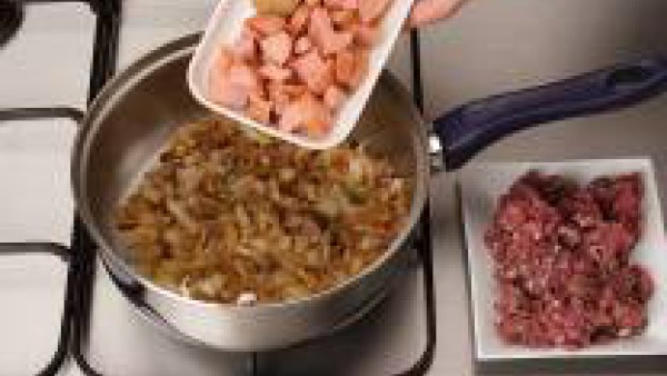 Dora la cebolla picada en una cazuela con un poco de aceite. Añade la carne de las salchichas, el pollo y la ternera hasta que se doren y consigas una masa homogénea.