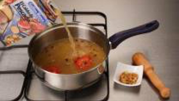 Agrega el caldo. Aparte, prepara una mezcla con los ajos, las almendras picadas, el azafrán y unas gotas de licor.