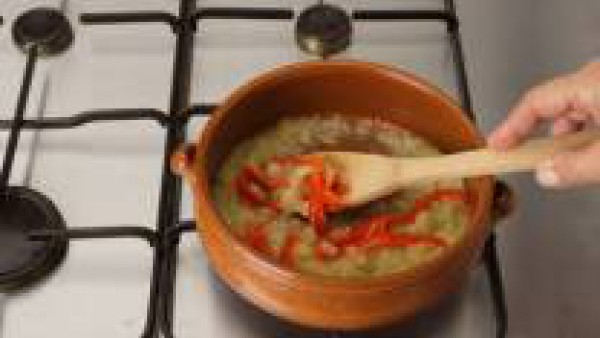 Pica los embutidos en dados, saltea en aceite en una cazuela y retira. Saltea el pimiento y el sofrito de cebolla. Rehoga el arroz y añade al caldo, después de cocer los huesos de jamón dentro.