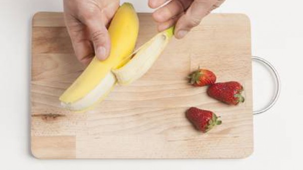 Pela todas las frutas y córtalas a gajos.  Limpia las fresas. 