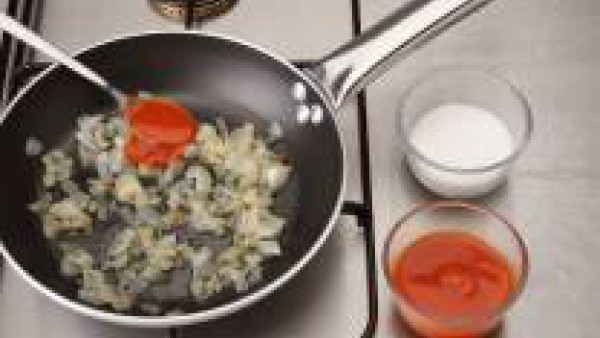 En el mismo aceite sofríe el ajo, el pimiento verde y el pimiento rojo. Cuando esté doradito, agrega el sofrito y añade el azúcar y el zumo de limón. Remueve y deja cocer durante unos 10 minutos.