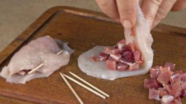 Trocea el jamón en dados y filetea las pechugas de pollo. Rellena las pechugas con el jamón troceado, ciérralas y pínchalas con un palillo para que se mantengan cerradas.