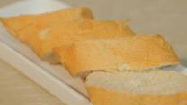Corta el pan en rebanadas cortadas al bies y el pimiento a tiras finas.