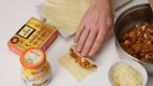 Reparte el preparado sobre los canelones y enrolla. Pon un poco de Tomate Frito en Trozos en el fondo de una fuente para horno y dispón encima los canelones.