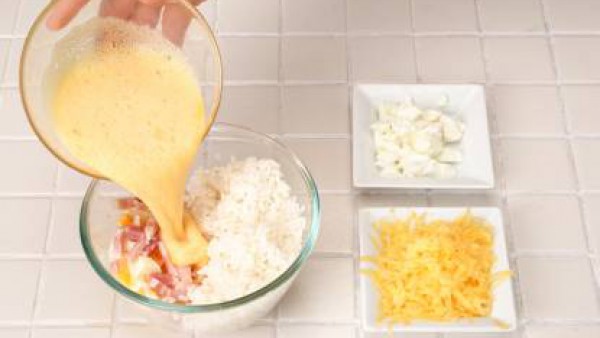 En un bol, pon el arroz, el huevo duro picado, el bacón y los quesos finamente picados.