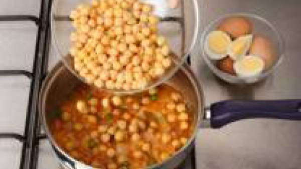 Vierte los garbanzos ya cocidos sobre el sofrito, mezcla y cuece a fuego lento unos minutos más.
