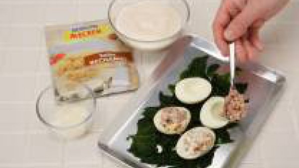 Prepara la Salsa Bechamel con la leche y siguiendo las instrucciones del sobre. En una fuente de horno, pon las espinacas en el fondo y los huevos encima. Cubre con la Salsa bechamel y el queso rallad