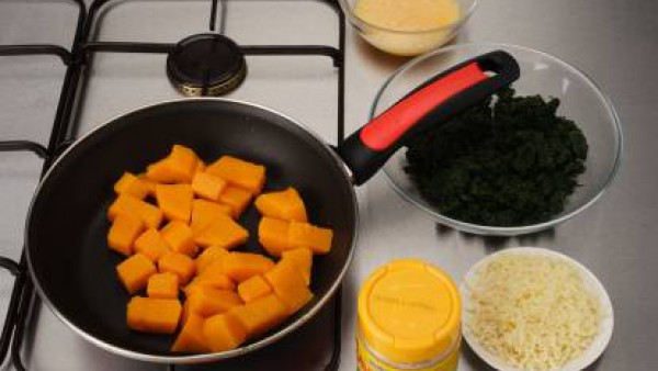 Pela la calabaza, quita las semillas y corta en dados. Cuece las espinacas. Pela y pica la cebolla y saltéala en el aceite. Escurre las espinacas, pícalas y saltéalas. Aparta. Añade la calabaza y deja