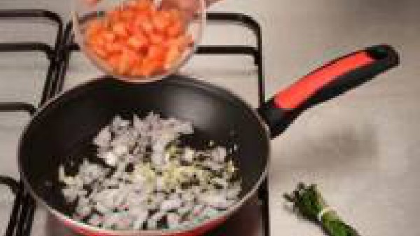 En una sartén, rehoga los dientes de ajo pelados y trinchados, la cebolla picada y el tomate frito junto con el atillo de hierbas.