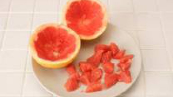 Parte los pomelos por la mitad, en horizontal. Vacíalos con un cuchillo y con cuidado para no romper las cáscaras.   Pela los gajos y córtalos en trozos menudos. Cuece la pechuga de pollo en agua con 