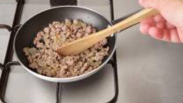 Pela la cebolla, pícala bien fina y rehógala en una sartén con el aceite unos cinco minutos. Añade las carnes y dóralas unos 5 minutos más removiendo de vez en cuando.