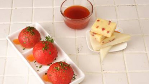 Dispón los tomates en una fuente de servir, riégalos con el fondo de cocción caramelizado y espolvoréalos con la sal gorda. Decora con las hojitas de albahaca y sírvelos acompañados de los quesos.