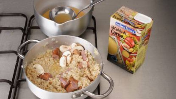 Echa el arroz, remueve para integrarlo y vierte el vino tinto. Cuando el arroz haya absorbido el vino, añade 2 cucharones de Caldo Casero de Pollo 100% Natural Gallina Blanca caliente y deja que el ar