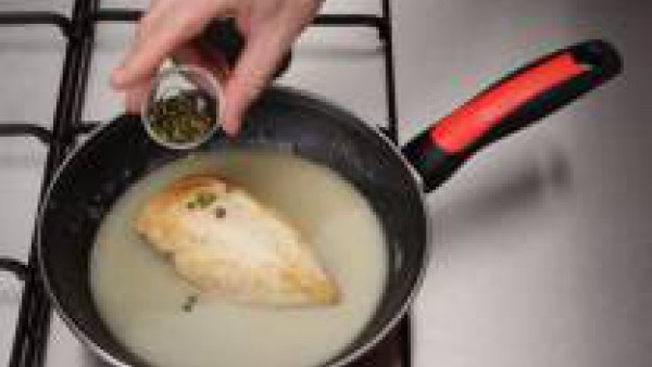 Recoge todo el jugo de la cocción del pollo en un cazo. Exprime el limóm y reserva el zumo obtenido. Cuece los granos de pimienta verde en el jugo de cocción del pollo durante unos minutos. Añade la n