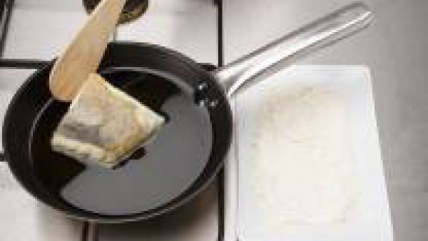 Enharina el bacalao y fríelo en una sartén con 4 cucharadas de aceite caliente durante 2 min.