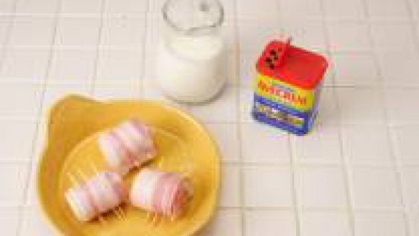 Dispón los rollitos en una fuente de horno engrasada, riega con el vino y baña con la nata líquida.