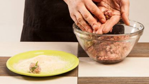 Enharina con pan rallado y fríe ligeramente las albóndigas en una cazuela con aceite, añade las zanahorias y los champiñones bien escurridos, seguidamente vierte el caldo. 