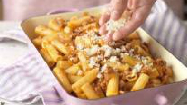 Remueve para que quede todo bien mezclado y pon los macarrones en una bandeja de horno. Espolvorea con el queso rallado y gratínalos bajo el grill del horno hasta que la superficie tenga un bonito col