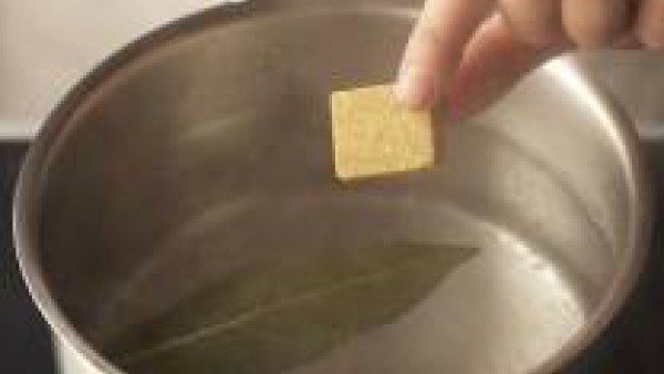 Pela y pica las cebollas y el diente de ajo. Lava el perejil, sécalo con papel absorbente y pícalo finamente. Lava el pimiento, sécalo y córtalo en tiras. Lleva a ebullición abundante agua en una cazu