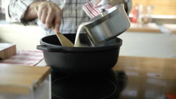 Añadir la leche en hilo, removiendo con una cuchara de madera para que se integre bien. Cocer a fuego lento hasta que la masa empiece a desprenderse de las paredes de la sartén. Añadir el pollo picado