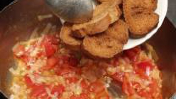 Una vez rehogadas las verduras, echa las rebanadas de pan frito y moja con el caldo de pescado.
