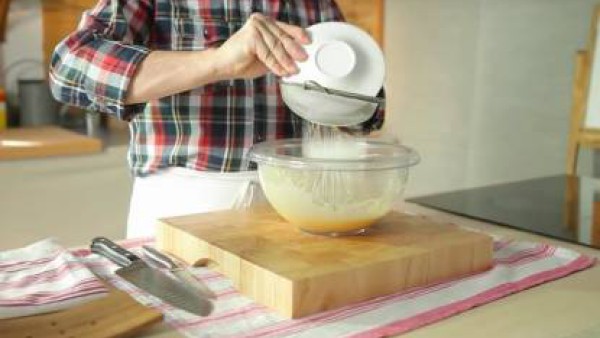Aparte, bate las yemas y el huevo entero con el azúcar. Mézclalos hasta que obtengas una pasta blanca.  Pon la maicena dentro de un colador e incorpórala, despacio y en forma de lluvia dentro de la me