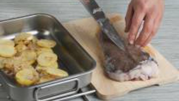 Vierte las patatas y las cebollas doradas en una fuente de horno, añade los lomos de rape con pimienta y el caldo. Cuece el pescado en el horno a 210ºC durante unos 20 minutos.