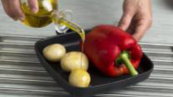 Pon a cocer en el horno a 220 ºC los pimientos rojos y las patatas enteras.