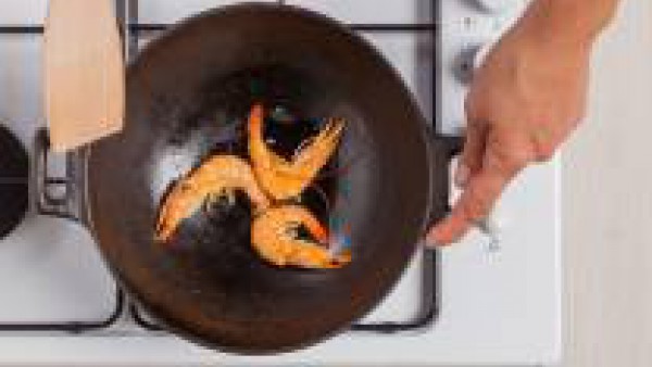 Saltea las gambas en el wok con un poco de aceite de oliva y 1 pastilla de Avecrem Dúo Paella de Pescado. Pica finamente el aguacate con la ayuda de un cuchillo afilado.