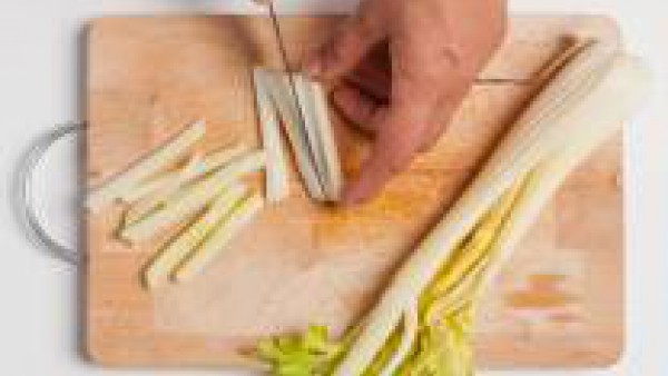 Lavar y limpiar las verduras. Cortar en tiras el apio y pelar y cortar en tiras finas las zanahorias.