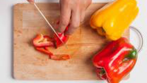 Lava los pimientos, quítales las semillas y córtarls.  Saltea los pimientos con el aceite de oliva virgen extra y un diente de ajo con piel.  Añade el Sofrito de Tomate y Verduras Gallina Blanca y coc