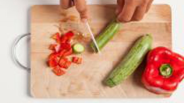 Corta las verduras en dados pequeños y dóralas en una sartén con poco aceite de oliva virgen extra .