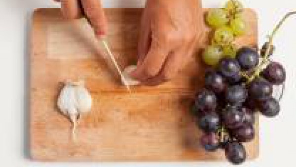 Limpia y corta los ajos; enjuaga las uvas blancas y rojas con agua corriente.