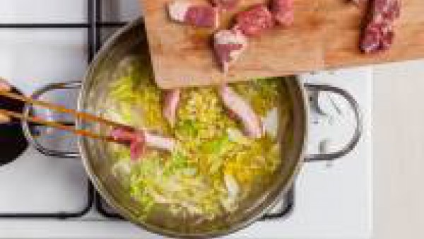 Agrega entonces la corteza, las salchichas y las costillas. Y, pasados 10 minutos, las bayas de enebro, y el repollo junto a 1 pastilla de Avecrem -30% Sal Carne. Cuece durante 20 minutos, añadiendo m