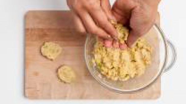 Después de 20 min., coge el cuenco de la nevera, forma la masa en bolas de puré de garbanzos y colócalos en una bandeja para hornear forrada con papel pergamino. Unta los falafels con 1 cucharada de a