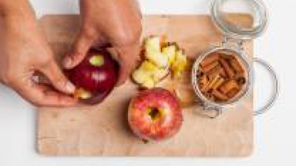 Rellena las cavidades practicadas a cada manzana con 1 rama de canela y 1 trozo de chocolate negro. Dispón las manzanas en una bandeja forrada con papel de horno, espolvorea con azúcar y hornea a 200 