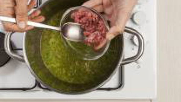 A continuación, añade la carne y continua la cocción durante otros 20 minutos. Mientras tanto, pon en el horno las rebanadas de pan untadas con 1 cucharada de aceite de oliva virgen extra y espolvorea