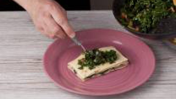 Monta la lasaña, para ello coloca en el fondo de cada plato una placa de lasaña, echa por encima 1 lámina de jamón y otra de queso. Añade por encima un poco de la mezcla de espinacas y tomate y repite