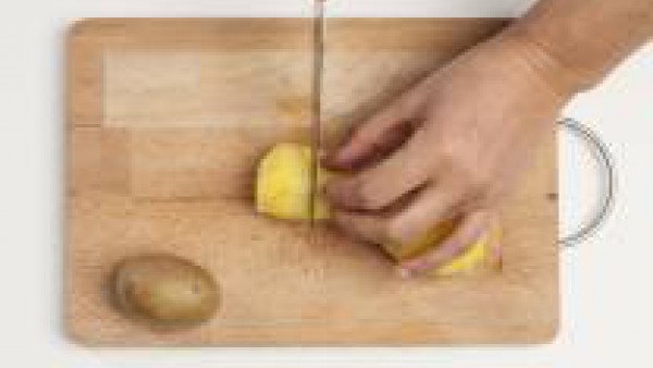 Mientras tanto, hierve las patatas en agua 1 pastilla de Avecrem Caldo de Pollo. Cuando estén cocidas, colócalas en una tabla de cortar, pélalas y córtalas por la mitad. Vacía un poco el interior de l