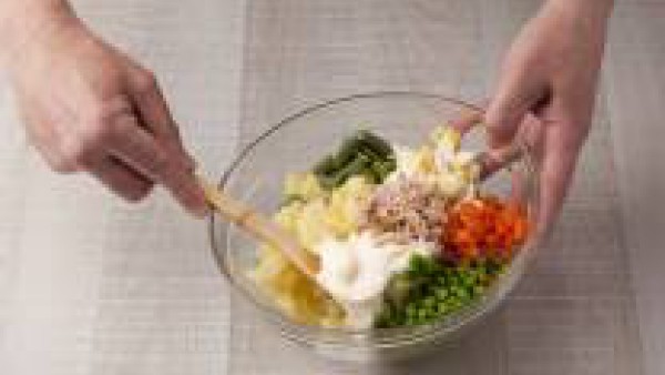 Mezcla en un cuenco las patatas, las zanahorias, los guisantes, las judías, los huevos, la mayonesa y el atún, y mézclalo con cuidado. Sírvelo con unas aceitunas por encima y unas tiras de pimientos d