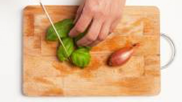 Limpia las hojas de albahaca con un paño húmedo y córtalas en tiras. Pica la cebolla finamente, saltea en aceite de oliva y, después de unos minutos, añade 3 cucharadas de tomate frito.