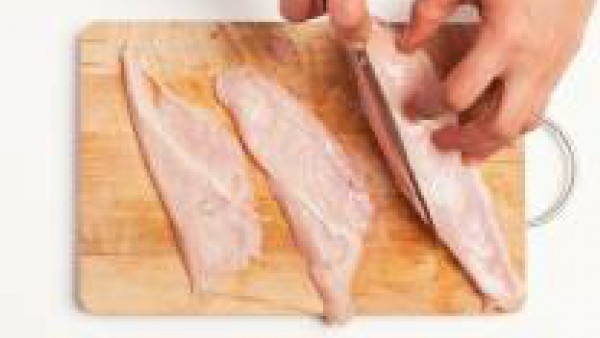 Corta la pechuga de pollo en rodajas no muy finas, después elimina cualquier hilo de grasa de la carne.