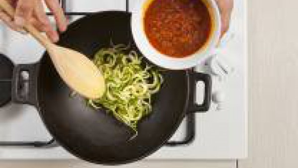Saltea los espaguetis con calabacín con el tomate frito y la carne picada. Sirve.
