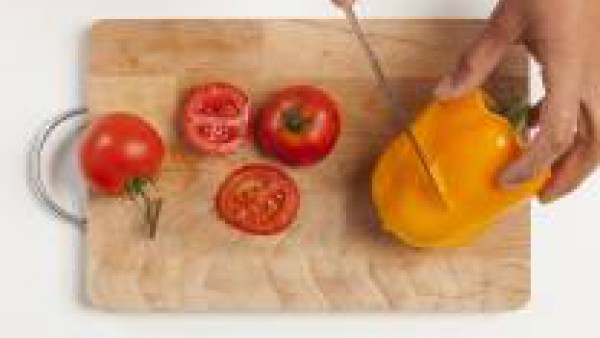 Lava las verduras; corta a rodajas longitudinales los calabacines, los tomates en rodajas y el pimiento en cuadrados. Por otra parte, en un bol, diluye el pesto con 1 cucharada de aceite de oliva.