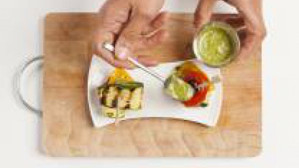 En un plato, forma torres con las verduras a la parrilla, alternando por el color. Utiliza un palillo para fijar el pincho. Adorna con 1 cucharada de pesto y sirve como aperitivo.