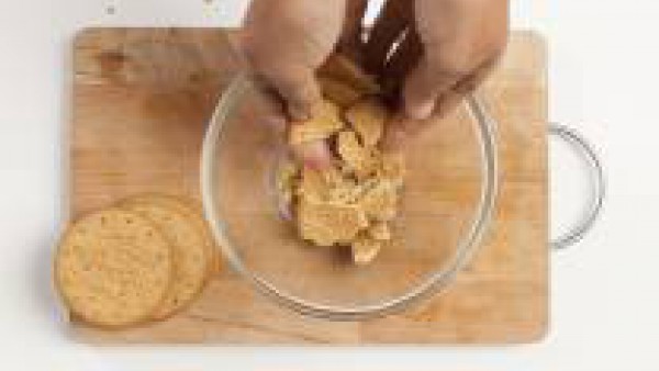 Mientras tanto, en un tazón, desmenuza las galletas integrales. 