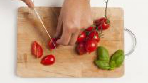 Lava los tomates y córtalos en trozos. Enjuaga y pica la albahaca.